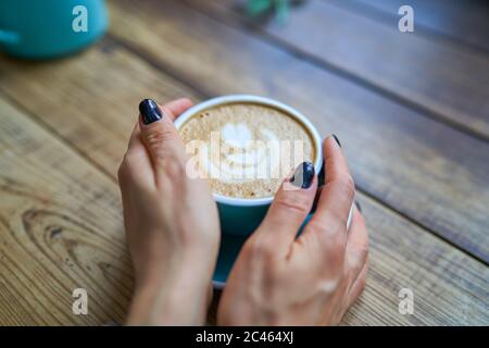 Eine Tasse leckeren starken Kaffee in weiblichen Händen. Konzept Getränke, Lifestyle, Arbeit, Hintergrund Stockfoto