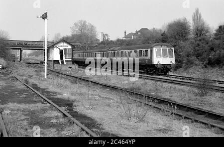 Ein Diesel-Mehreinheit-Zug, der an der Three Spires Junction Signalbox, Coventry, England, Großbritannien, vorbeifährt. April 1987. Stockfoto