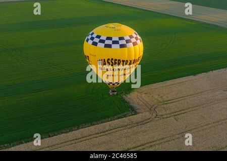 Cloppenburg, Deutschland. Juni 2020. Die Band 'Crackerjacks' landet mit einem Heißluftballon auf einer Weide, nachdem sie ein Ballonkonzert über der Stadt Cloppenburg (aufgenommen mit einer Drohne) veranstaltet haben. Kredit: Mohssen Assanimoghaddam/dpa/Alamy Live Nachrichten Stockfoto