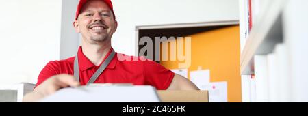 Guy Kurier in Uniform hält Paket und Dokument Stockfoto