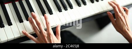 Schöne weibliche Hände liegen auf einem digitalen Klavier Stockfoto