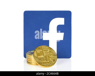 Kiew, Ukraine - 10. April 2019: Facebook-Symbol auf Papier gedruckt und mit Kryptowährungsmünzen platziert. Facebook entwickelt eine eigene Kryptowährung für remi Stockfoto