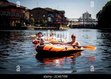 Die Menschen segeln in aufblasbaren Schlauchbooten in den Londoner Docklands, vor der Skyline von Canary Wharf, während des offiziell heißesten Tages des Jahres bisher. Stockfoto