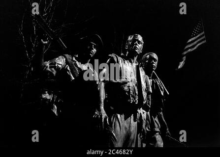 Vietnam Veterans Memorial Washington DC USA 1988. Die drei Soldaten von Friedrich Hart. Hier bei Nacht mit den Sternen und Streifen (Old Glory) im Hintergrund gesehen. Die drei Soldaten (auch bekannt als die drei Soldaten) ist eine Bronzestatue von Friedrich Hart. Enthüllt am Veterans Day, November 11, 1984[ auf der National Mall, ist es Teil des Vietnam Veterans Memorial zum Gedenken an den Vietnam-Krieg. Es war die erste Vertretung eines Afrikaners auf der National Mall. Stockfoto