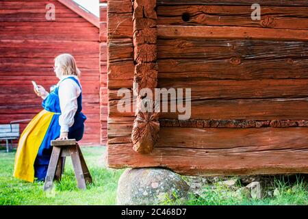 UPPSALA, SCHWEDEN - 27. Jul 2016: Frauen in traditioneller Kleidung mit einem Handy. Schweden Nationalfeiertag, Stockfoto