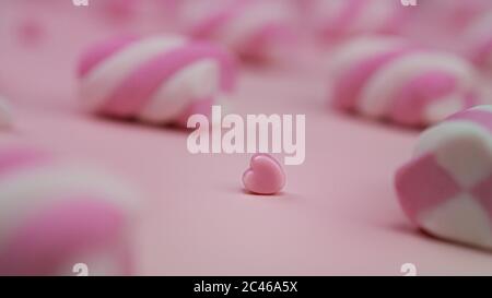 Viele rosa Marshmallows auf einem rosa Hintergrund und Herz dazwischen. Valentinstag. Stockfoto