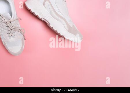 Moderne, stylische beige Damen Sneaker auf rosa Hintergrund. Stockfoto