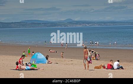 Portobello, Edinburgh, Schottland, Großbritannien. 24. Juni 2020. Das heiße Wetter brachte Familien raus, aber am Meer war nicht viel los, am Strand und an der Promenade gab es viel Platz, um sich in sozialer Distanz zu halten. Menschen auf verschiedenen Paddle Boards und Schlauchboote. Stockfoto