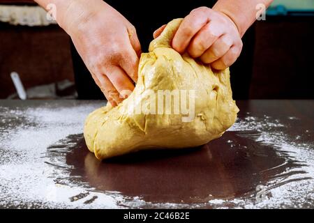 Roher Pizzateig in den Händen des Küchenchefs für die Herstellung von Pizza. Stockfoto