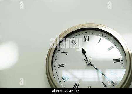 Klassische Uhr an einer weißen Wand im Haus. Nahaufnahme. Leerzeichen für Text Stockfoto