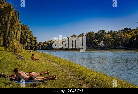 Italien Piemont Turin Valentino Park Menschen auf der Sonnenwiese am Ufer des Flusses Po Stockfoto