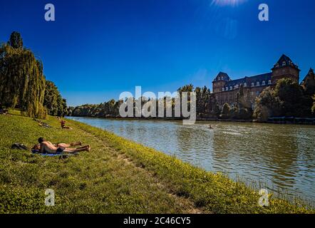 Italien Piemont Turin Valentino Park Menschen auf der Sonnenwiese am Ufer des Flusses Po Stockfoto