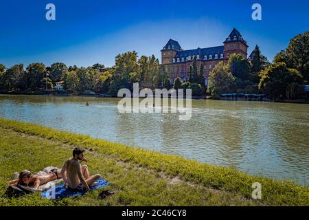 Italien Piemont Turin Valentino Park Menschen auf der Sonnenwiese am Ufer des Flusses Po Stockfoto