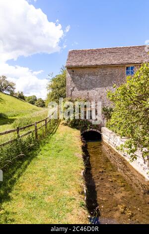 Rosen wachsen über dem Mühllauch der Winson Mill im Coln Valley im Cotswold Dorf Winson, Gloucestershire UK Stockfoto