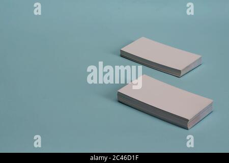 Leere Visitenkarten auf hellblauem Hintergrund. Zwei Stapel weißer neuer Visitenkarten diagonal auf einem schlichten Hintergrund. Werbung, Branding. Oben vi Stockfoto