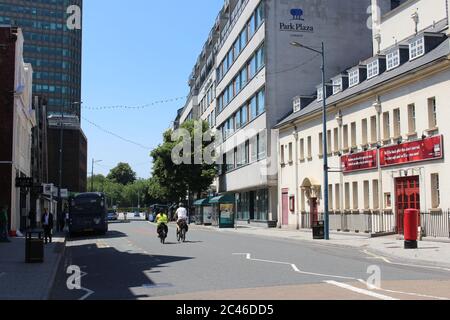 Ein Foto von 2 Radfahrern in einer ruhigen Straße in Cardiff. Greyfriars Road. Normalerweise ist es mit Bussen, Autos und Taxis voll. Stockfoto