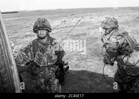 Zwei Soldaten führen die Gruppe von einem Lynx Hubschrauber während der Kampfspiele auf Salisbury Plain in in den frühen 1990er Jahren. Wiltshire. GROSSBRITANNIEN. Stockfoto