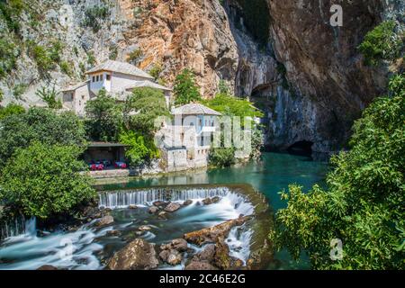 Ein Wasserfall in Blagaj in Bosnien und Herzegowina. Gebäude können gesehen werden. Stockfoto