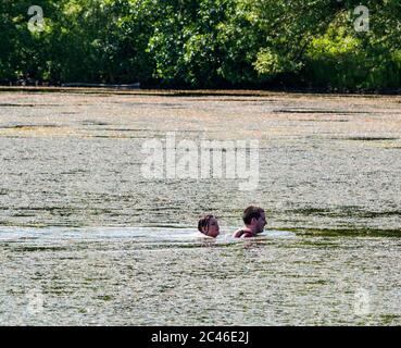 Musselburgh Lagunen, East Lothian, Schottland, Großbritannien, 24. Juni 2020. Wetter: Jugendliche schwimmen in einer Lagune trotz der Pflanzen im See während der Hitzewelle Stockfoto