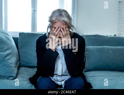 Einsam depressiv ältere alte Witwe Frau weinend auf Couch in Isolation zu Hause, traurig und besorgt vermissten Mann und Familie in COVID-19 Ausbruch, Stockfoto