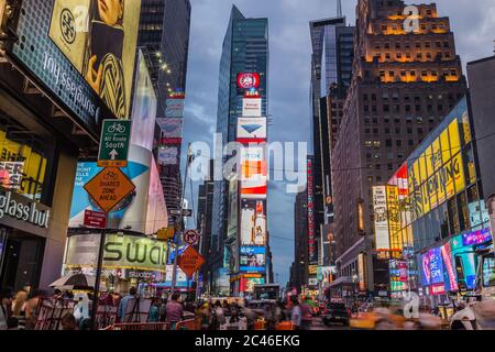 NEW YORK CITY, USA - 31. AUGUST 2014: Time Square in der Dämmerung zeigt Taxis, die vorbeifahren und beleuchtete Werbetafeln Stockfoto
