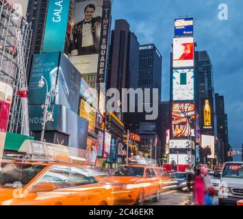 NEW YORK CITY, USA - 31. AUGUST 2014: Time Square in der Dämmerung zeigt Taxis, die vorbeifahren und beleuchtete Werbetafeln Stockfoto