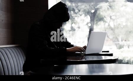 Silhouette Hacker Eingabe Laptop auf Café und Entfernung von sozialen mit Banner Größe Stockfoto