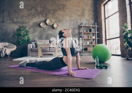 Full size Profil Seite Foto von schönen aktiven sportlichen Mädchen tun Stretching Arme Wirbelsäule Pilates Meditation auf Matte genießen Pilates Anstrengung körperlich Stockfoto