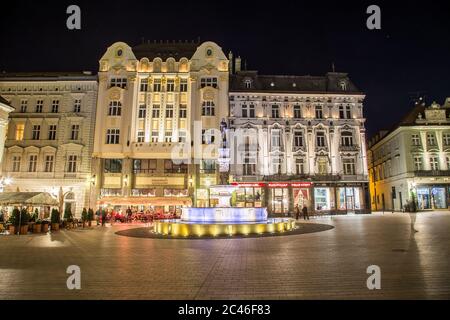 BRATISLAVA, SLOWAKEI - 29. APRIL 2016: Blick auf Gebäude und Maximilians Brunnen in der Altstadt Bratislava bei Nacht. Menschen und die Außenseite der Resta Stockfoto