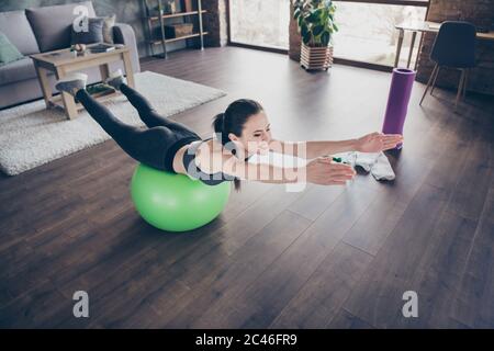 Profilfoto der schönen Dame Quarantäne Hobby Training Hause dynamische Pilates Stretching Üben Liegen auf fit Ball tun Übungen für alle Muskeln Stockfoto