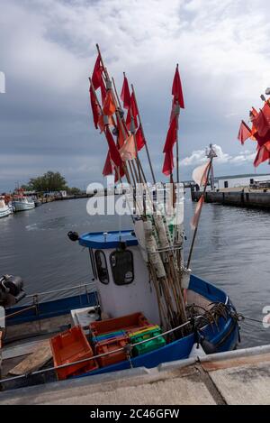 Hiddensee, Deutschland. Juni 2020. Ein blaues Fischerboot liegt im Hafen. Es hat rote Signalfahnen an Bord, um die Position der Fischernetze zu markieren. Quelle: Stephan Schulz/dpa-Zentralbild/ZB/dpa/Alamy Live News Stockfoto