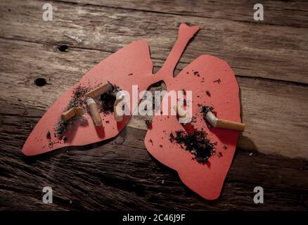 Konzeptuelles Bild von Zigaretten Stiche und Brennen auf roten Lungen isoliert auf rustikalem Hintergrund. Werbestil von Tabak und Lungenkrebs, Medical war Stockfoto
