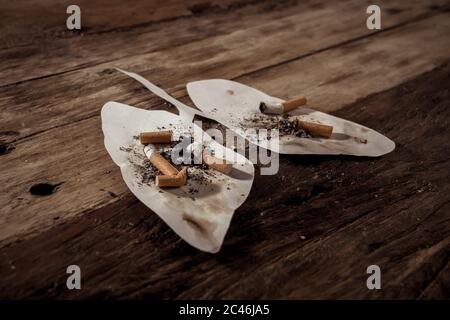 Konzeptuelles Bild von Zigaretten Stiche und Brennen auf schmutzigen Lungen isoliert auf rustikalem Hintergrund. Werbestil von Tabak und Lungenkrebs, Medical w Stockfoto