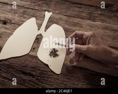 Werbestil Bild von Tabak und Lungenkrebs, Medizinische Warnung, aufhören zu rauchen und Rauchen tötet Kampagne. Konzeptionelles Bild der Hand mit Brennen Stockfoto