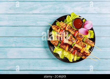 Hähnchenschinken Kebab auf Spieß mit Gemüse auf Holzhintergrund. Draufsicht. Stockfoto