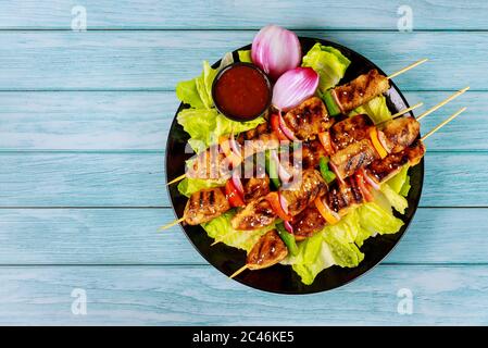 Hühnershish Kebab mit roter Zwiebel, Salat und Paprika. Draufsicht. Stockfoto