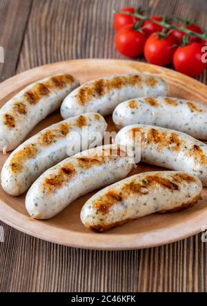 Gegrillte Würstchen mit einem Bündel Kirschtomaten auf dem Teller Stockfoto