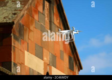 Nahaufnahme eine Drohne, die vor der Kirche fliegt, um die Trauung zu fotografieren Stockfoto