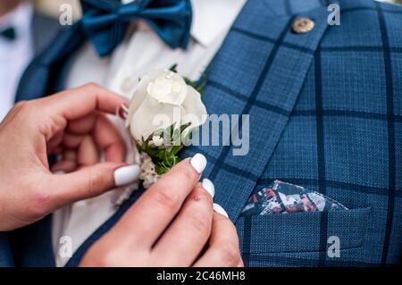 Braut trägt Bonbonniere auf der Bräutigam Jacke Stockfoto