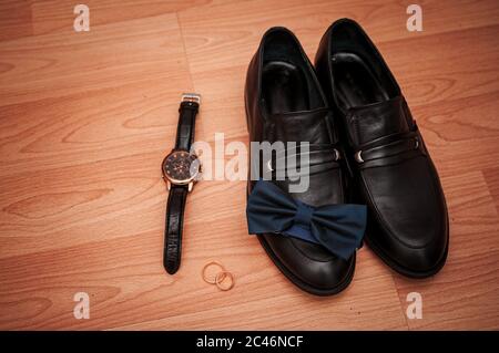 Schuhe Gold Ringe und Armbanduhr auf dem Tisch Stockfoto