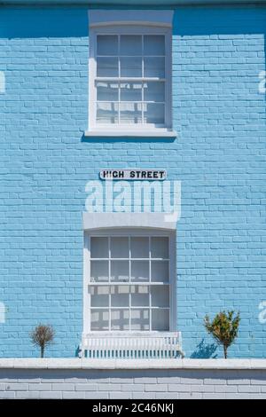 Außenansicht des alten Hauses mit pastellblauer Wand und weißen Fensterrahmen mit High Street Schild. Aldeburgh, Suffolk. GROSSBRITANNIEN Stockfoto