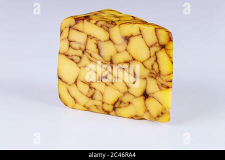 Stück Cheddar Irish Porter Käse auf weißem isolierten Hintergrund. Stockfoto