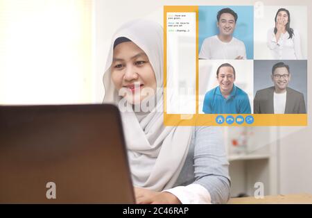 Asiatische muslimische Frau, die Telekonferenz wegen Coronavirus covid Pandemie. Webcam pc-Bildschirmansichten während der Gruppe Video-Anruf zeigt, die Menschen teilgenommen Stockfoto
