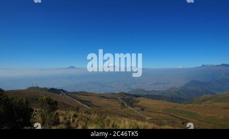 Blick auf die Stadt Quito mit dem Cotopaxi Vulkan im Hintergrund vom Rucu Pichincha - Ecuador Stockfoto