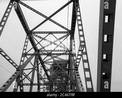 Metallkonstruktion der Eisenbahnbrücke mit dem aufsteigenden Mittelteil für die Durchfahrt von Schiffen. Blick von unten vom Fenster des Autos. Architektur, Designelemente Stockfoto