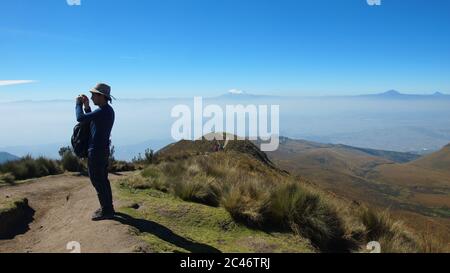 Quito, Pichincha / Ecuador - Juli 16 2017: Touristen fotografieren den Rucu Pichincha mit dem Antisana Vulkan im Hintergrund Stockfoto