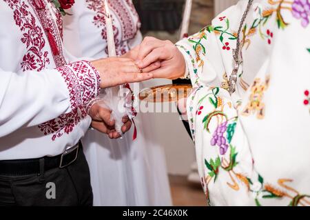 Priester kleidet Eheringe am Finger Stockfoto