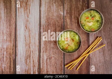 Zwei Schüsseln Hühnernudelsuppe mit Brotstäbchen. Stockfoto