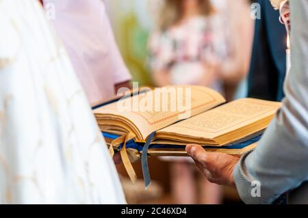 Der Mensch in der Kirche hält das Evangelium in der Hand Stockfoto
