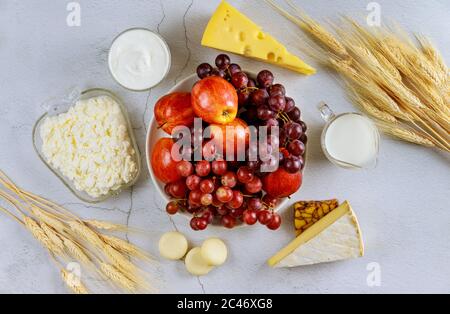 Ernte von Früchten, Milch, Käse und Weizen auf weißem Hintergrund. Stockfoto